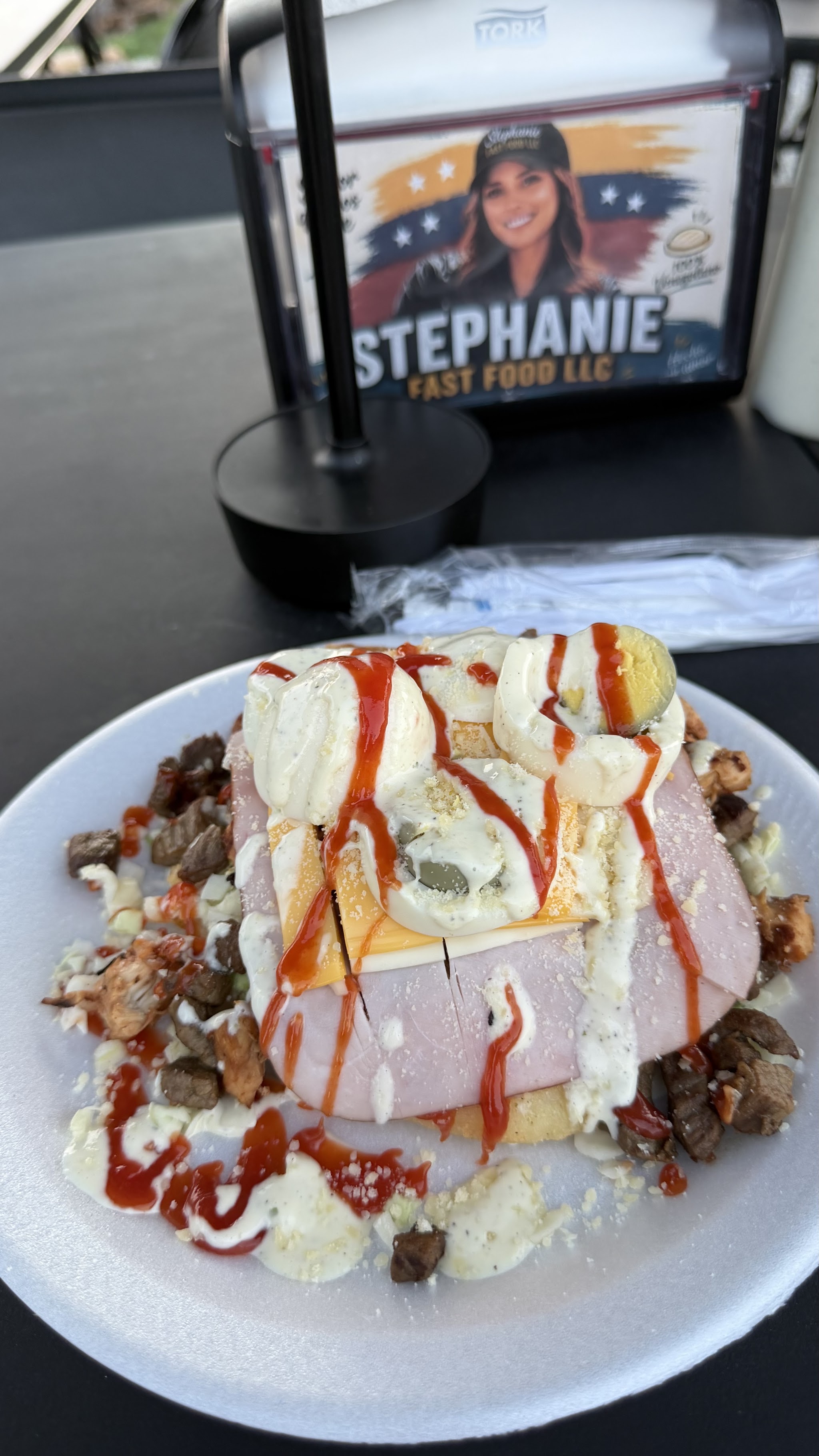 A plate piled with ham, cheese, egg, steak and chicken with our sauces